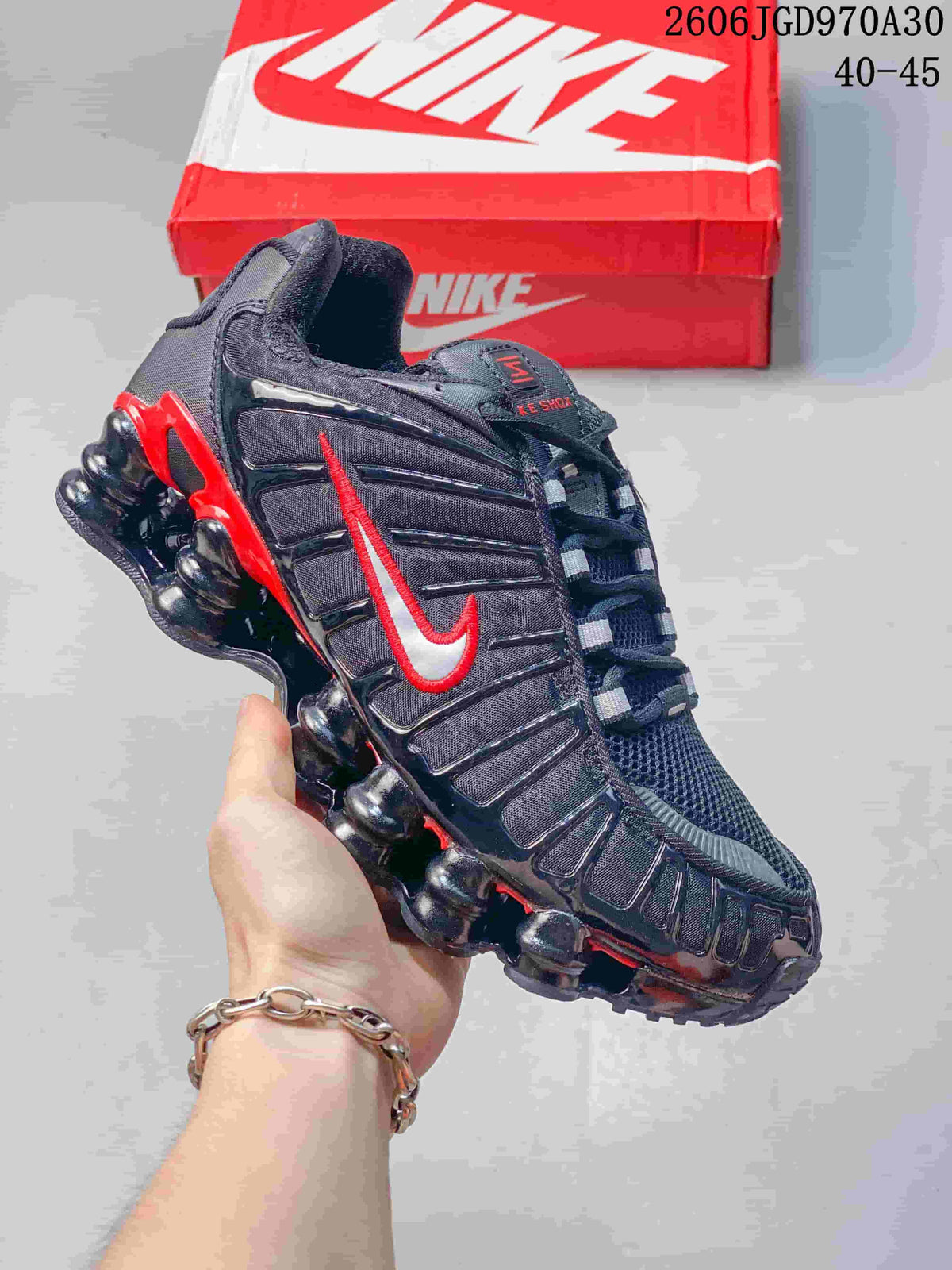 Black Nike Shox TL sneaker with red accents and sculpted segmented sole