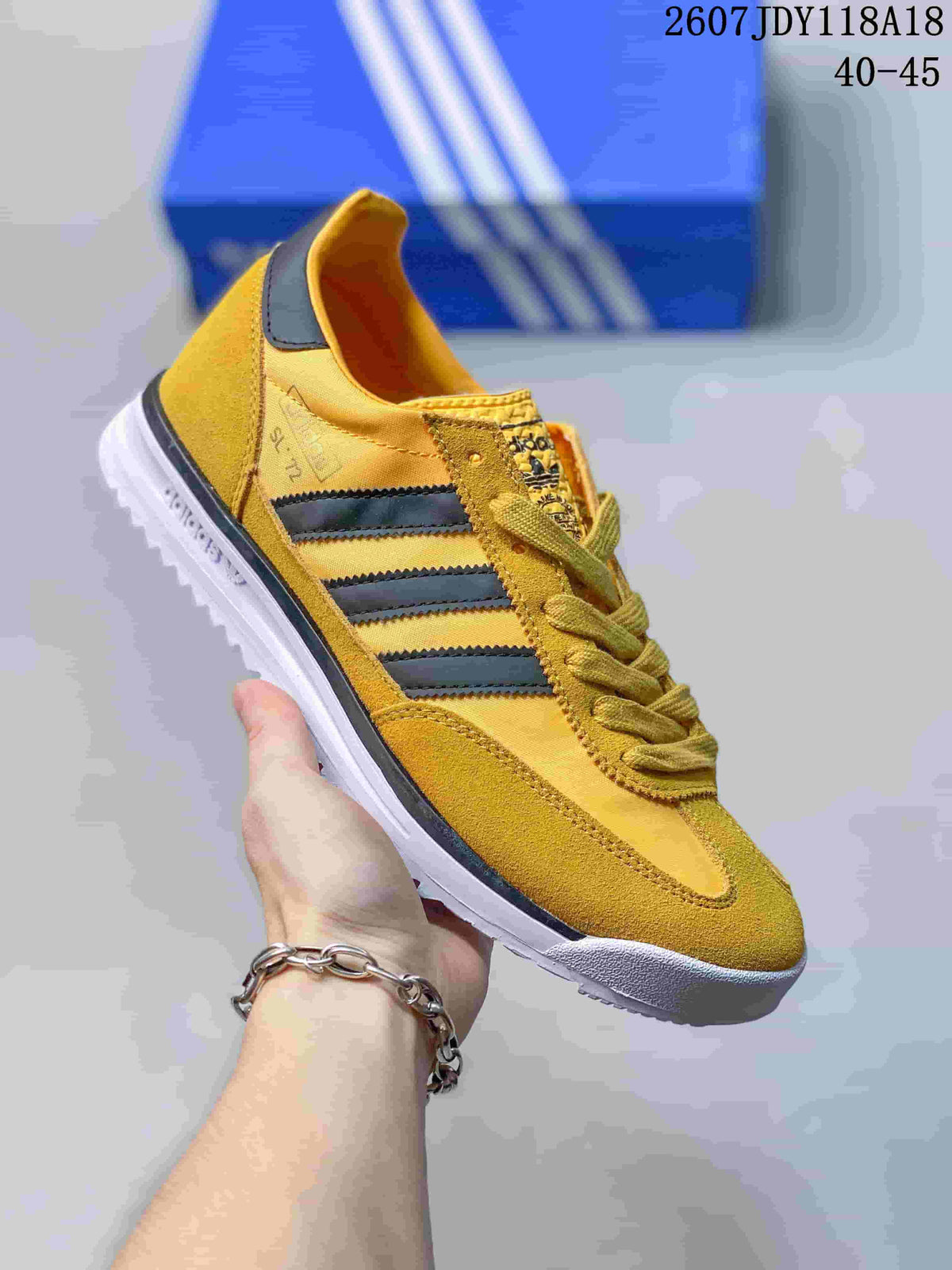 Yellow adidas SL 72 sneaker with dark stripes and a white outsole.
