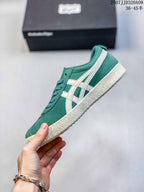 Side view showing the green upper, cream side stripes, lace-up front, and textured sole.