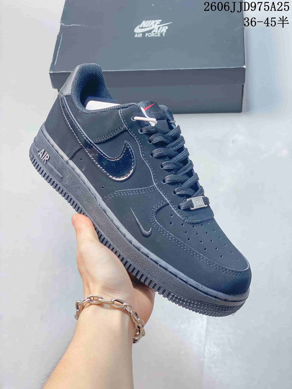 Angled side view of a black Nike Air Force 1 low-top sneaker showing the tonal Swoosh, heel AIR detail, and textured outsole.