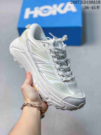 White HOKA Mafate Speed 2 sneaker with pale green and gray layered side graphics.