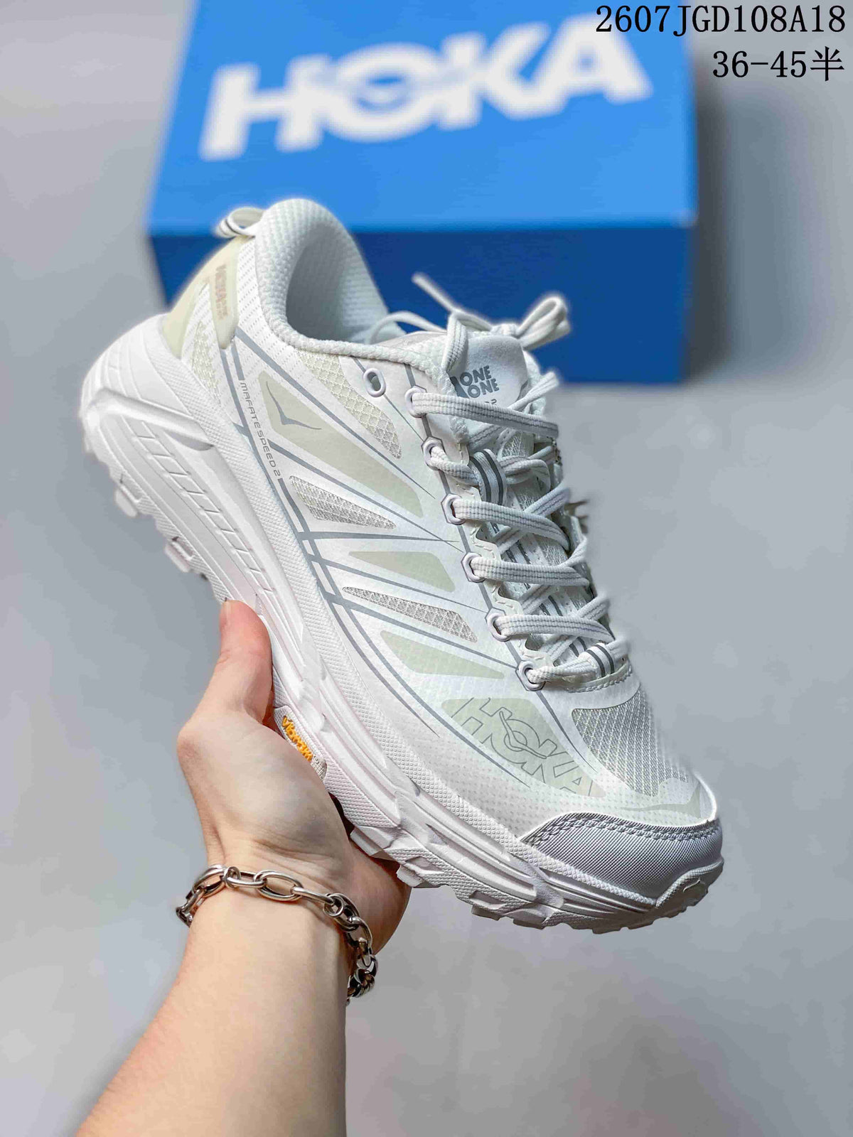 White HOKA Mafate Speed 2 sneaker with pale green and gray layered side graphics.