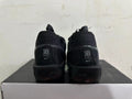Rear view of all-black Nike sneakers showing heel branding and black midsoles