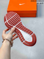 Close view of the sneaker outsole showing red traction sections and a patterned rubber tread.