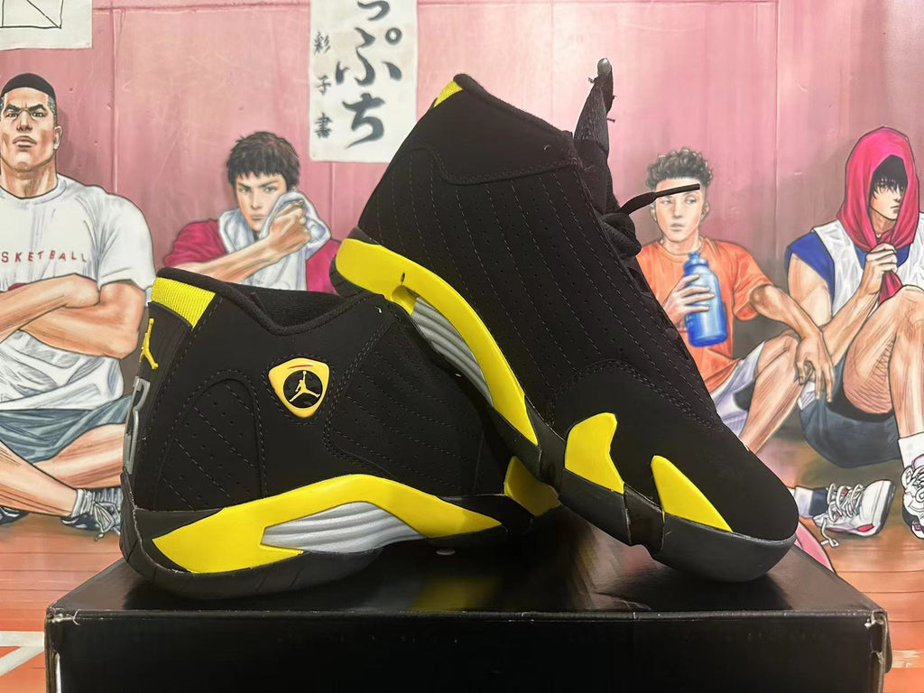 Pair of black and yellow high-top sneakers shown from the side