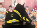 Pair of black and yellow high-top sneakers shown from the side