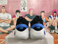 Rear view of black basketball shoes showing blue heel accents and white soles.