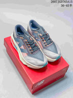 Pair of gray New Balance FuelCell SuperComp Trainer v2 running shoes displayed on a red shoebox.