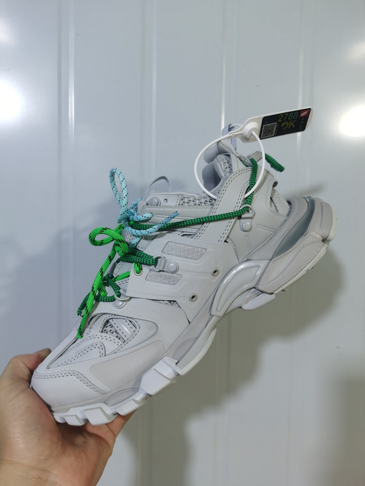 Close angled view of the grey Balenciaga Track Trail sneaker showing layered panels, mesh sections and contrasting laces.