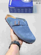 Angled side view of the blue two-buckle clog sandal with a textured outsole and branded buckle.
