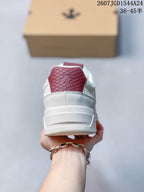 Rear view of the white sneaker showing the padded heel, layered midsole and burgundy tongue detail.