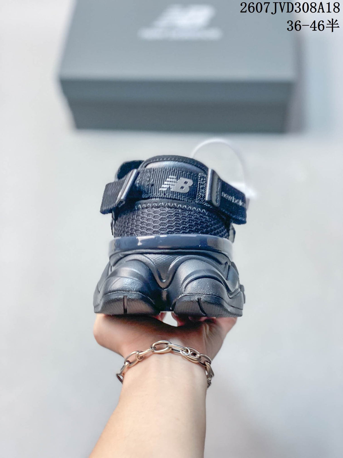 Rear view of a dark grey New Balance 9060 sneaker showing the padded collar, heel structure and outsole.