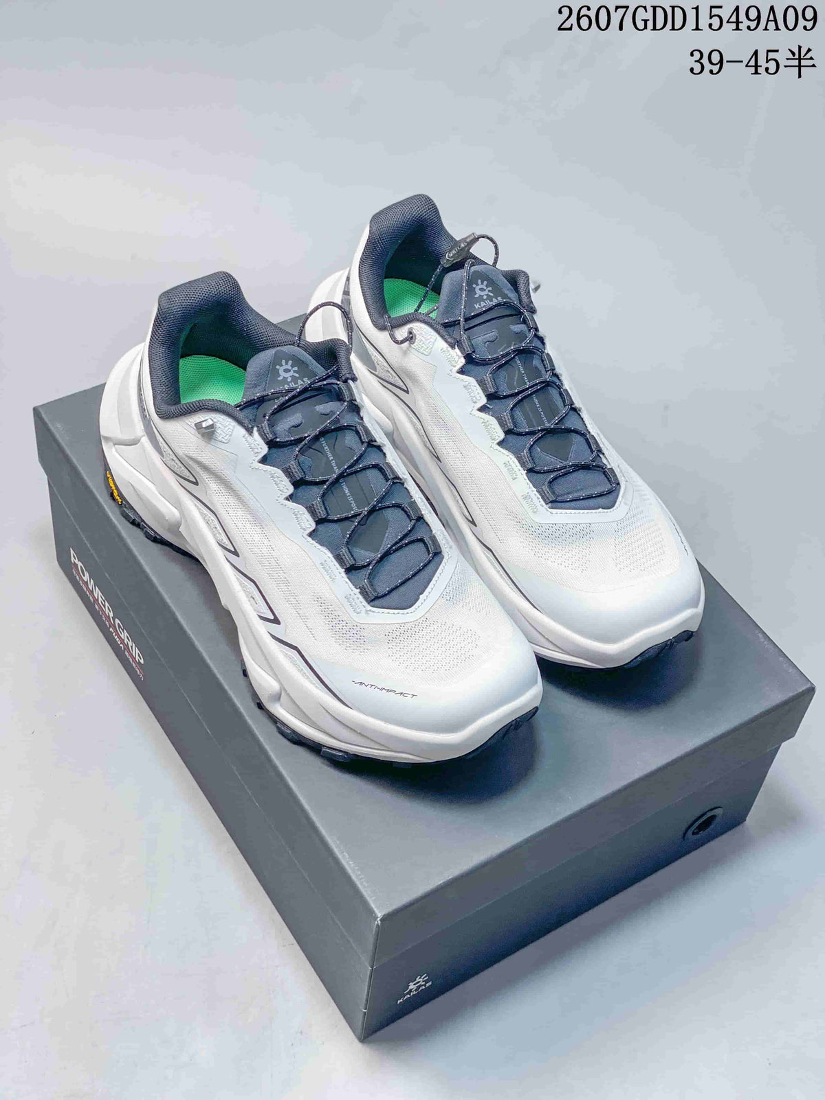 Pair of white and navy Kailas Fuga Ex 330 shoes displayed on a shoebox, with product code and size-range text visible above.
