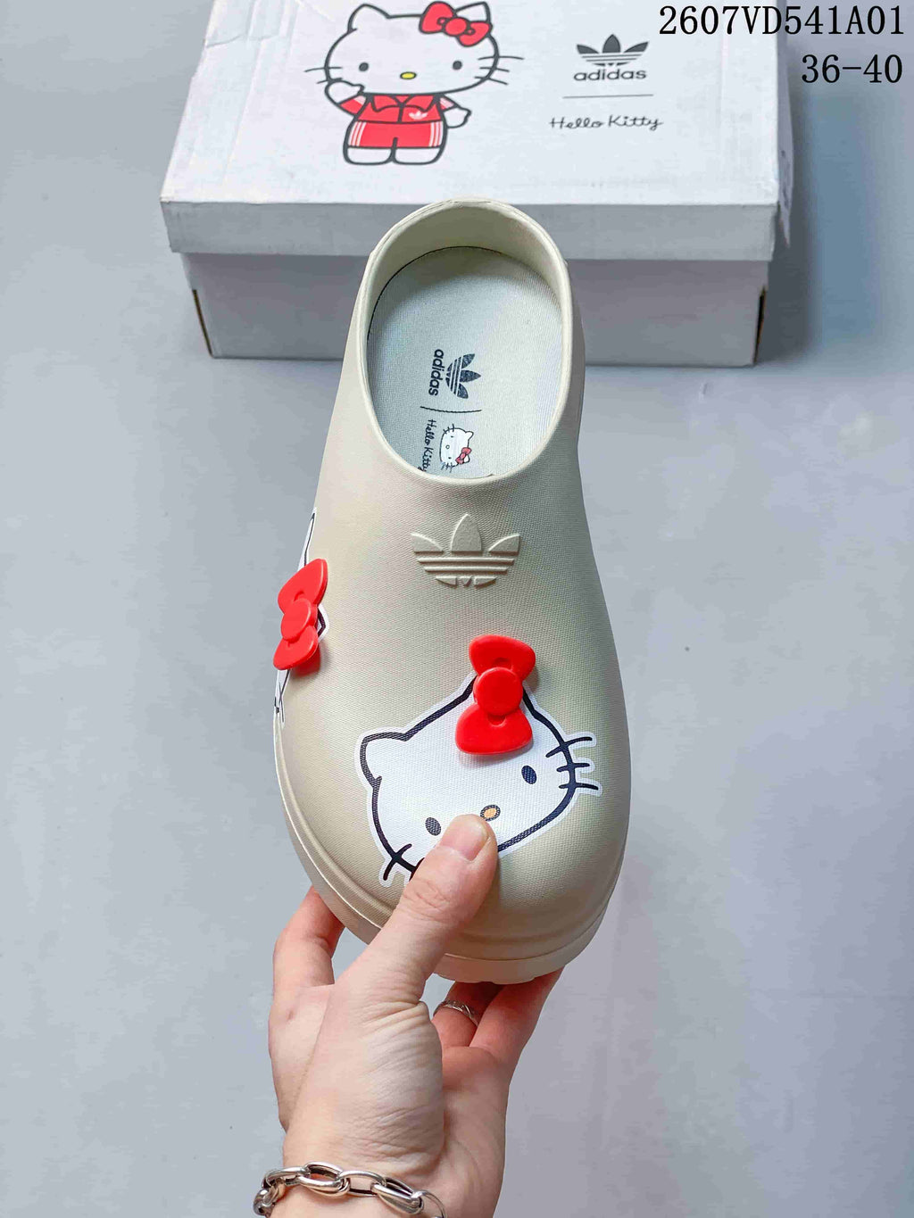 Top view of a cream mule clog with Hello Kitty graphics and red bows
