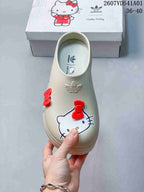 Top view of a cream mule clog with Hello Kitty graphics and red bows