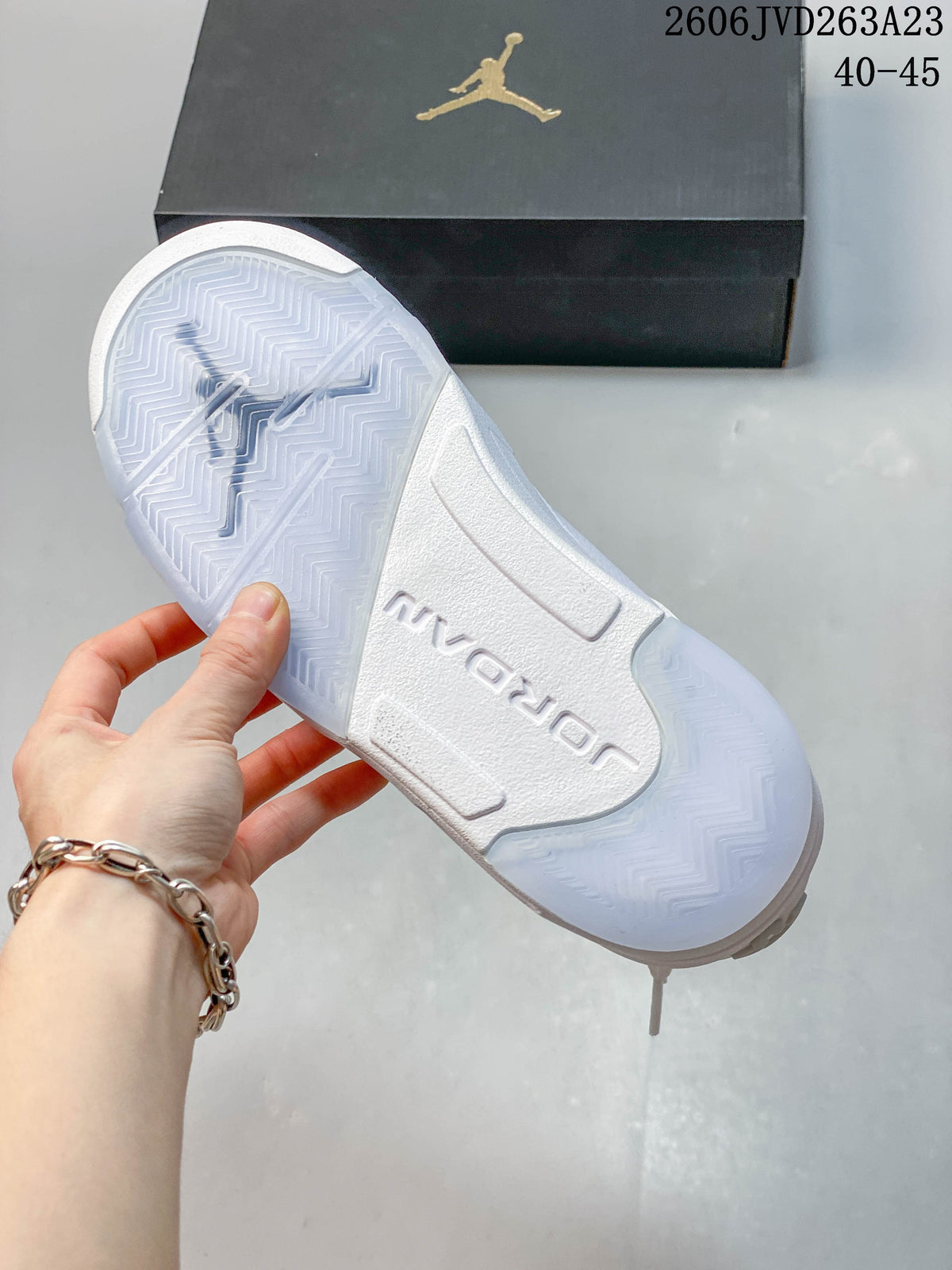 Underside of a white Jordan sneaker showing the patterned outsole and central Jordan lettering