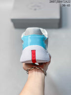Rear view of the turquoise and white sneaker showing the white heel section and red branded pull detail.