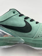 Side close-up of the perforations, black Swoosh and green midsole