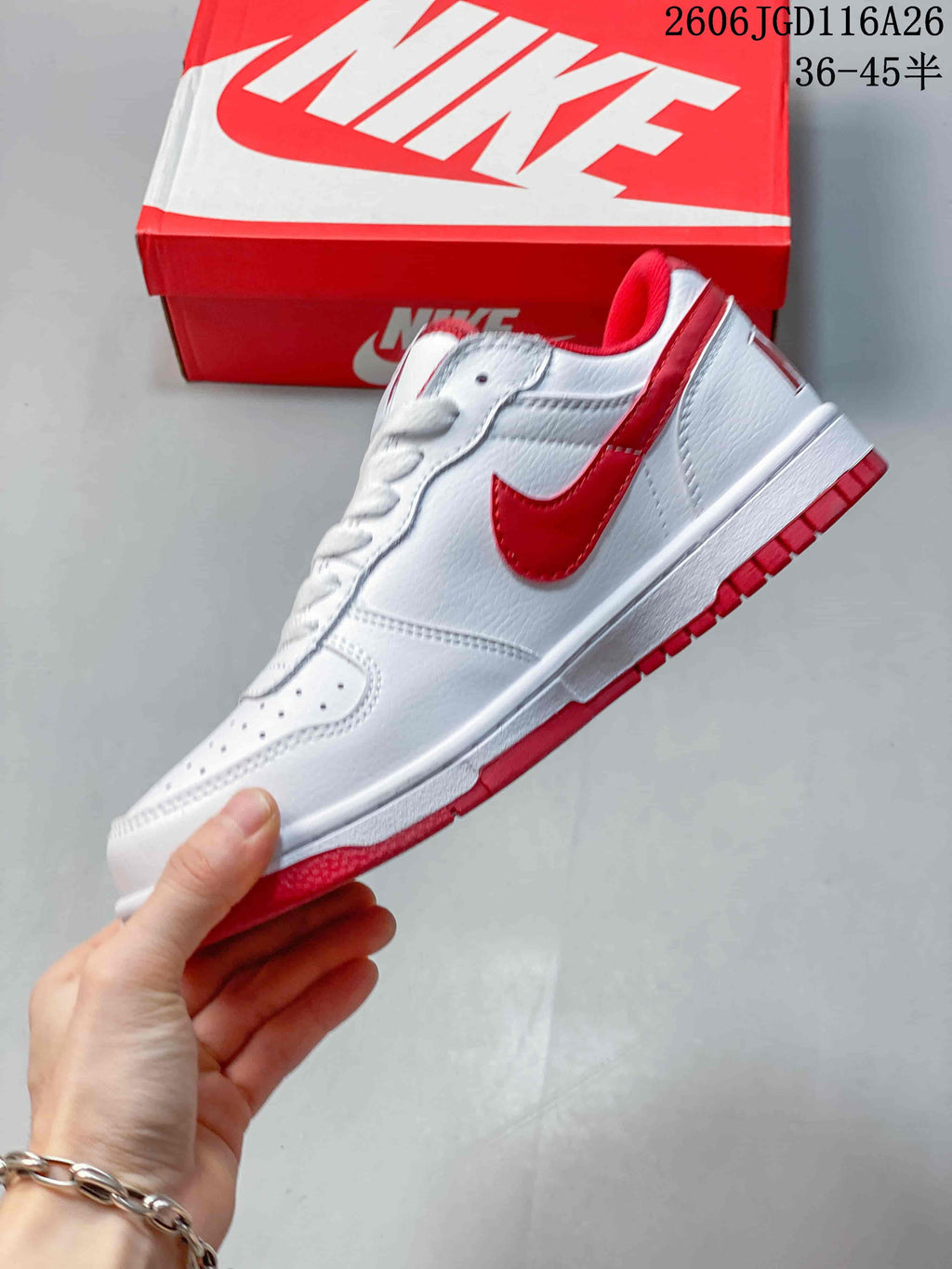 Side view of the white low-top sneaker with red Swoosh and red outsole