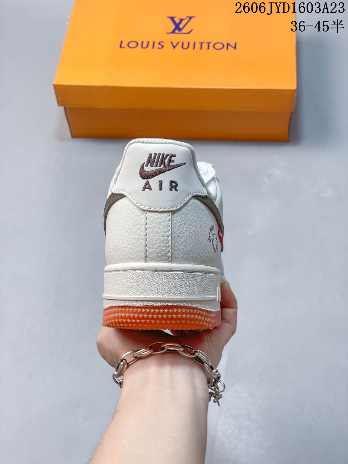 Rear view of the sneaker showing the heel panel, branding, and gum-orange outsole