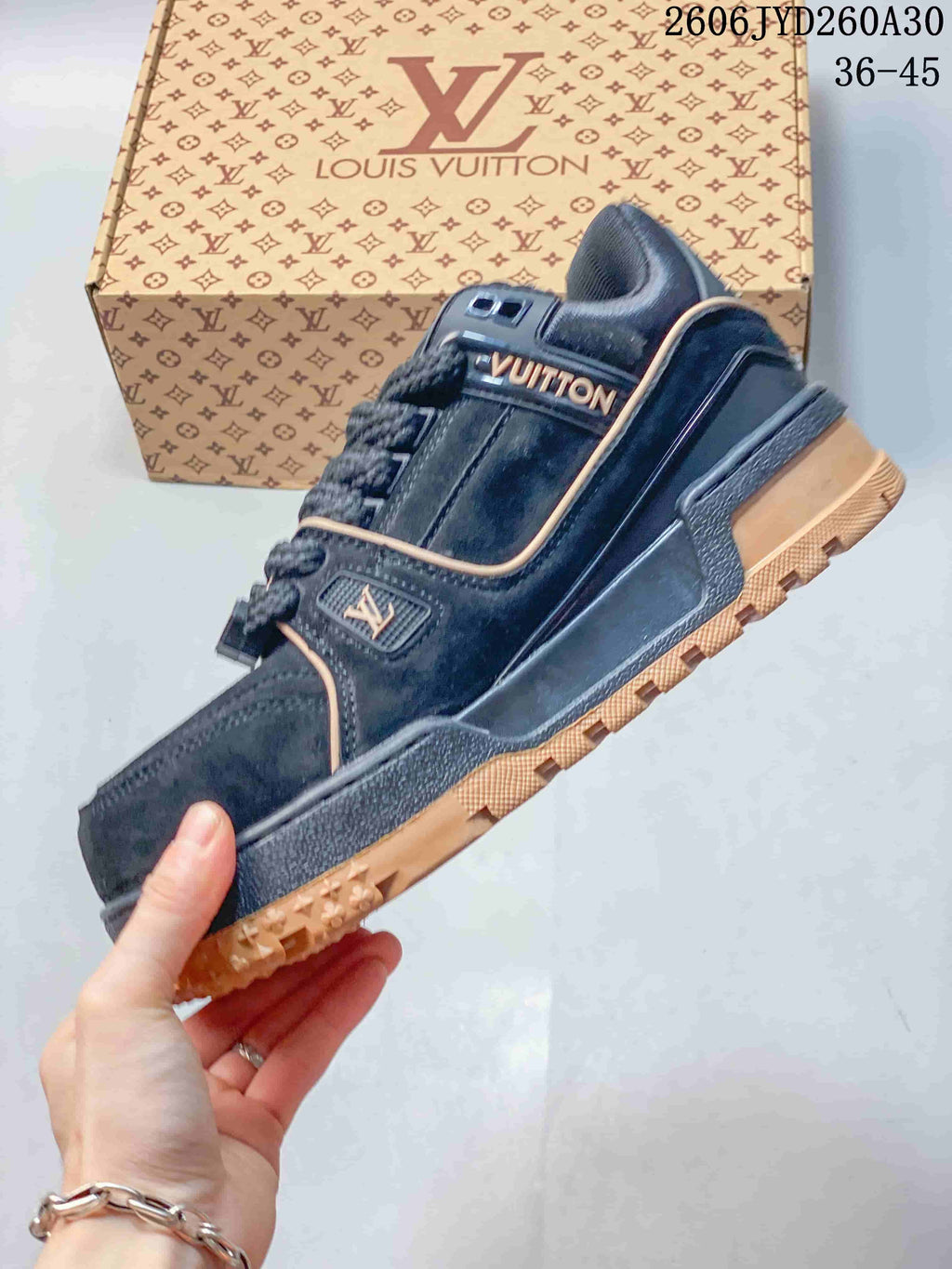 Side profile of a navy low-top sneaker with tan trim and patterned outsole