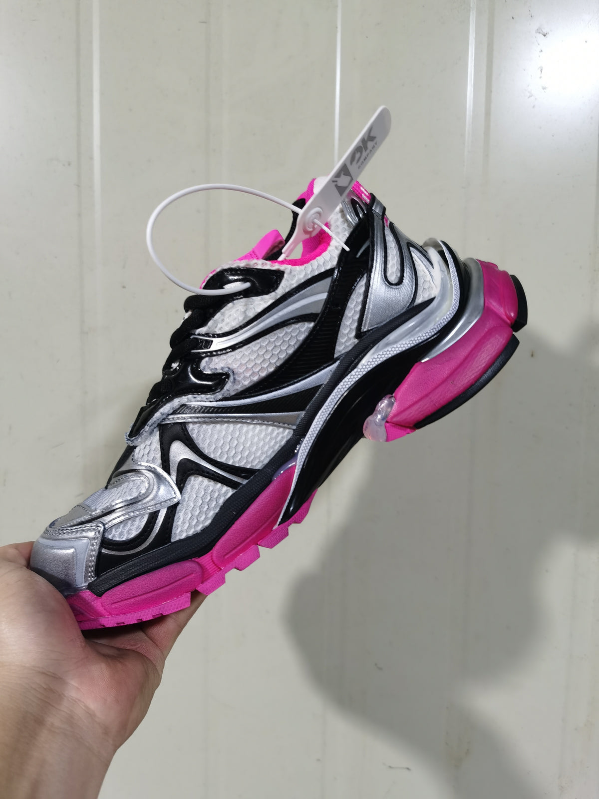 Side and underside view of the Balenciaga Runner 2 sneaker highlighting the contrasting pink outsole, silver panels, and black trim.