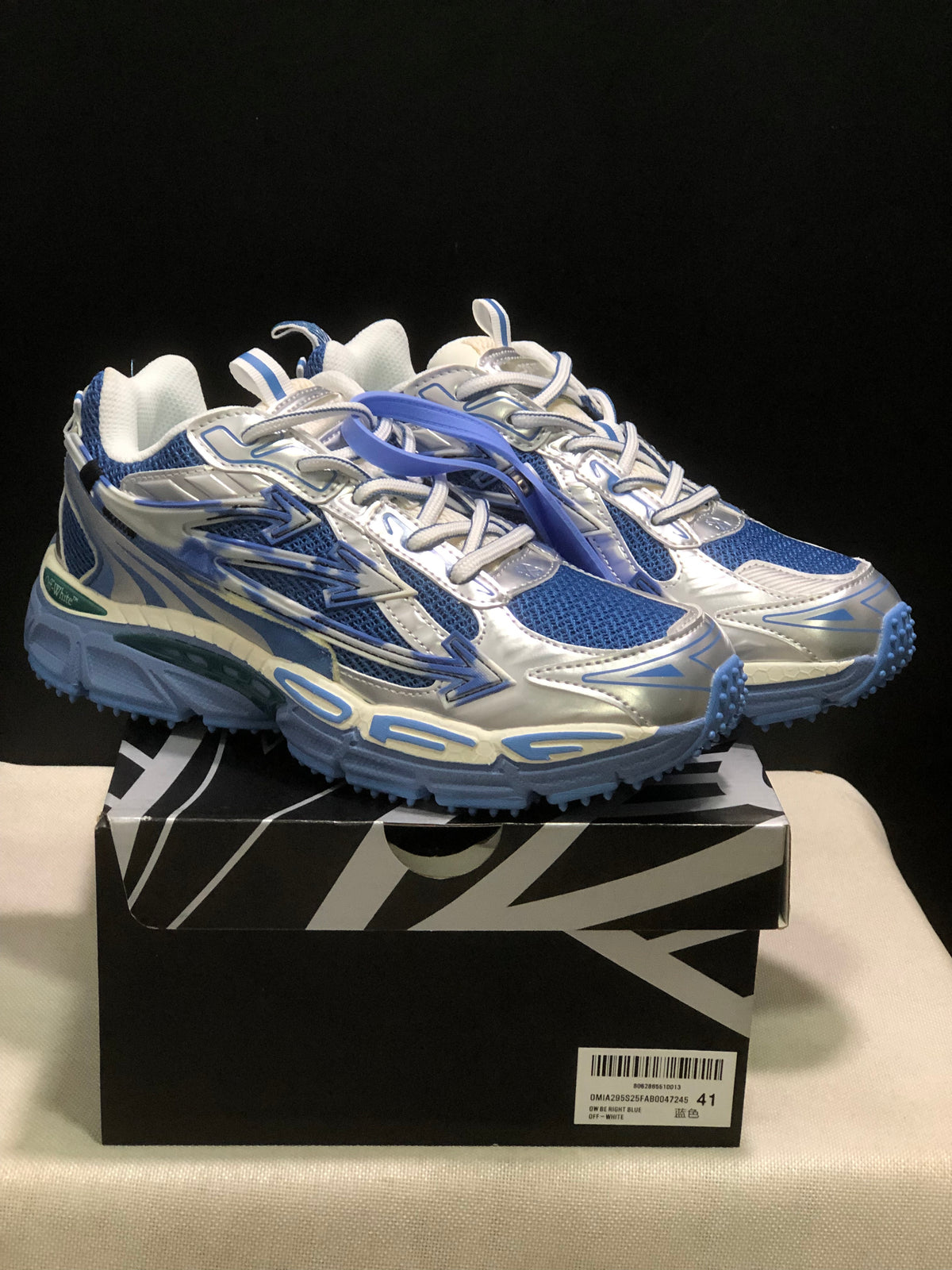Pair of blue, white, and silver Off-White Be Right Back sneakers displayed on a branded box.