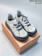 Pair of light gray and off-white Norda hiking shoes with dark laces on a Norda box.