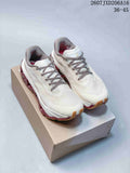 Pair of white On Cloudmonster 3 Hyper shoes with burgundy and gum outsole details displayed on a shoe box.
