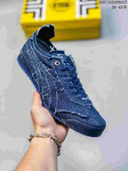 Angled side view of the blue sneaker showing the layered upper, side stripes and patterned rubber sole.
