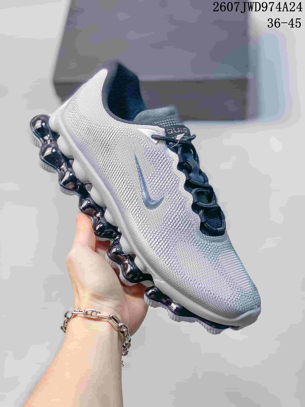 Angled side view of a silver-gray and white Nike Air Liquid Max sneaker with the Nike Swoosh and segmented outsole visible.
