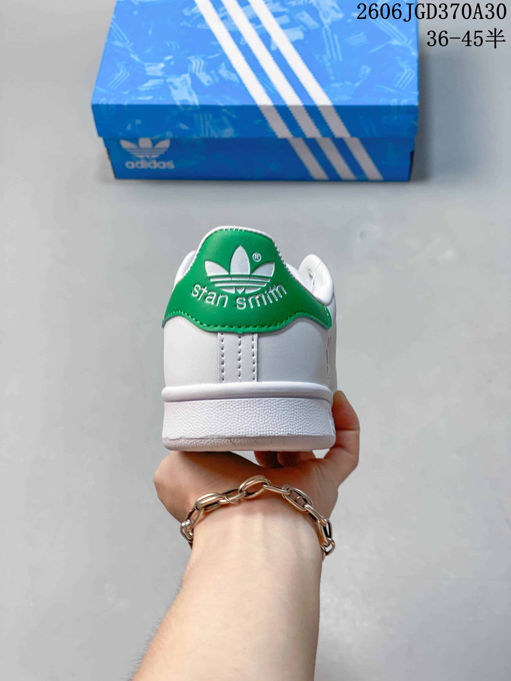 Rear view of a sneaker with a green heel tab and Stan Smith lettering