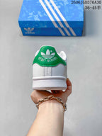 Rear view of a sneaker with a green heel tab and Stan Smith lettering
