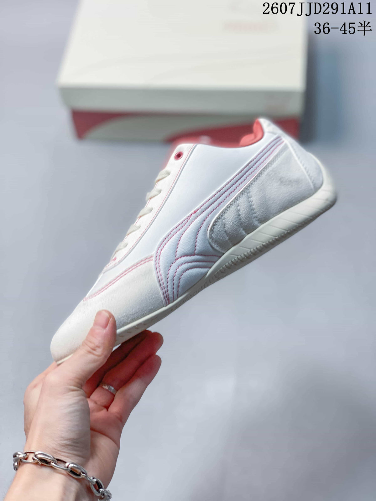 Side profile showing the white upper, pink-red stitching, Puma side branding, and low-profile sole.