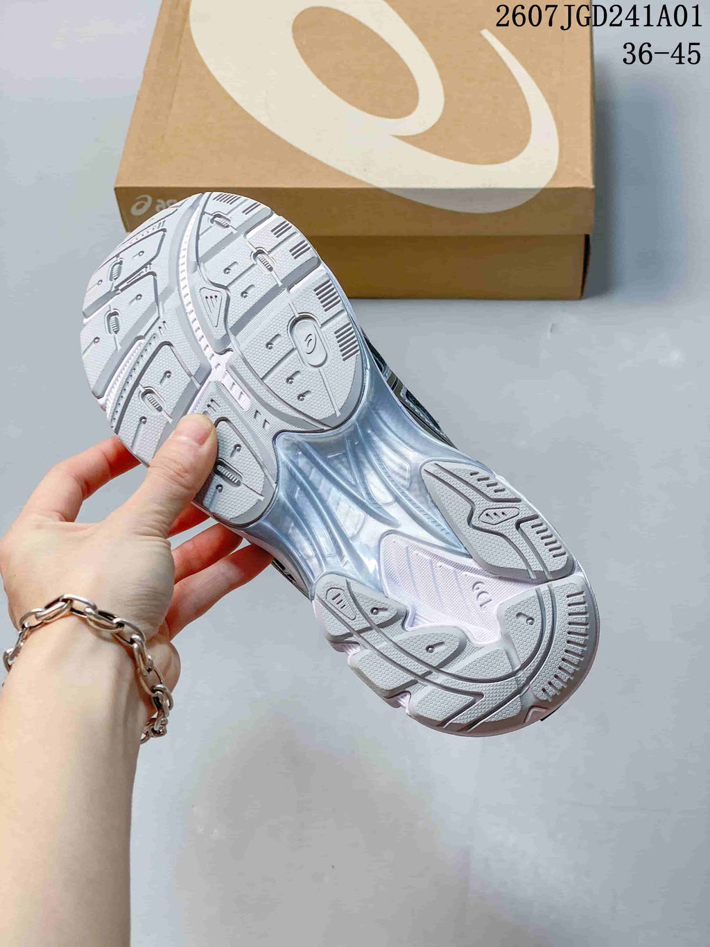 Close-up of the patterned outsole on a silver-toned ASICS GT-2160 Breeze sneaker.