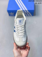 Top view showing the white lace-up upper, tongue branding, and blue side detailing.