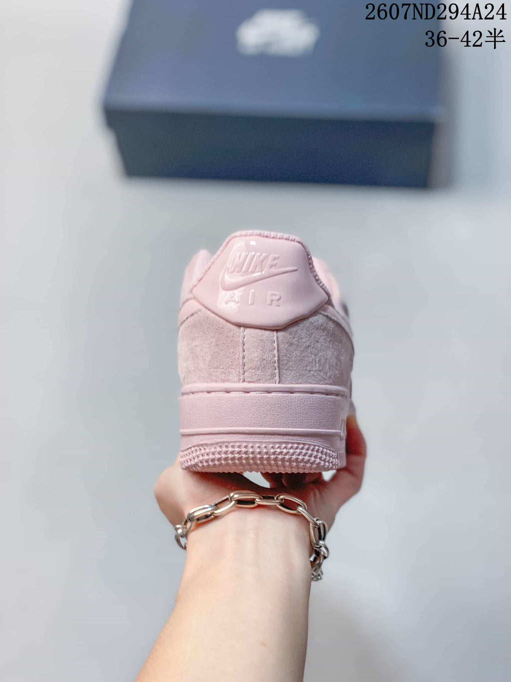 Rear view of a soft pink sneaker showing the Nike Air branding and padded heel collar.
