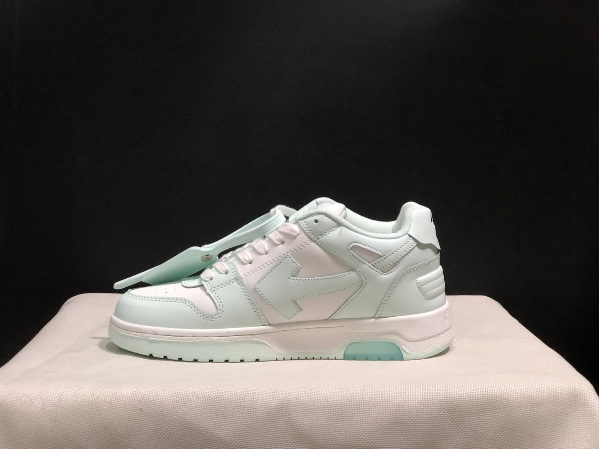 Clean side profile of a white low-top sneaker showing layered construction, large side detailing and mint outsole inserts.