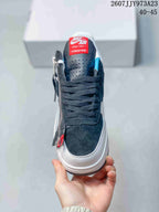 Front view showing the perforated dark toe box, black laces, red tongue label, and side zipper.