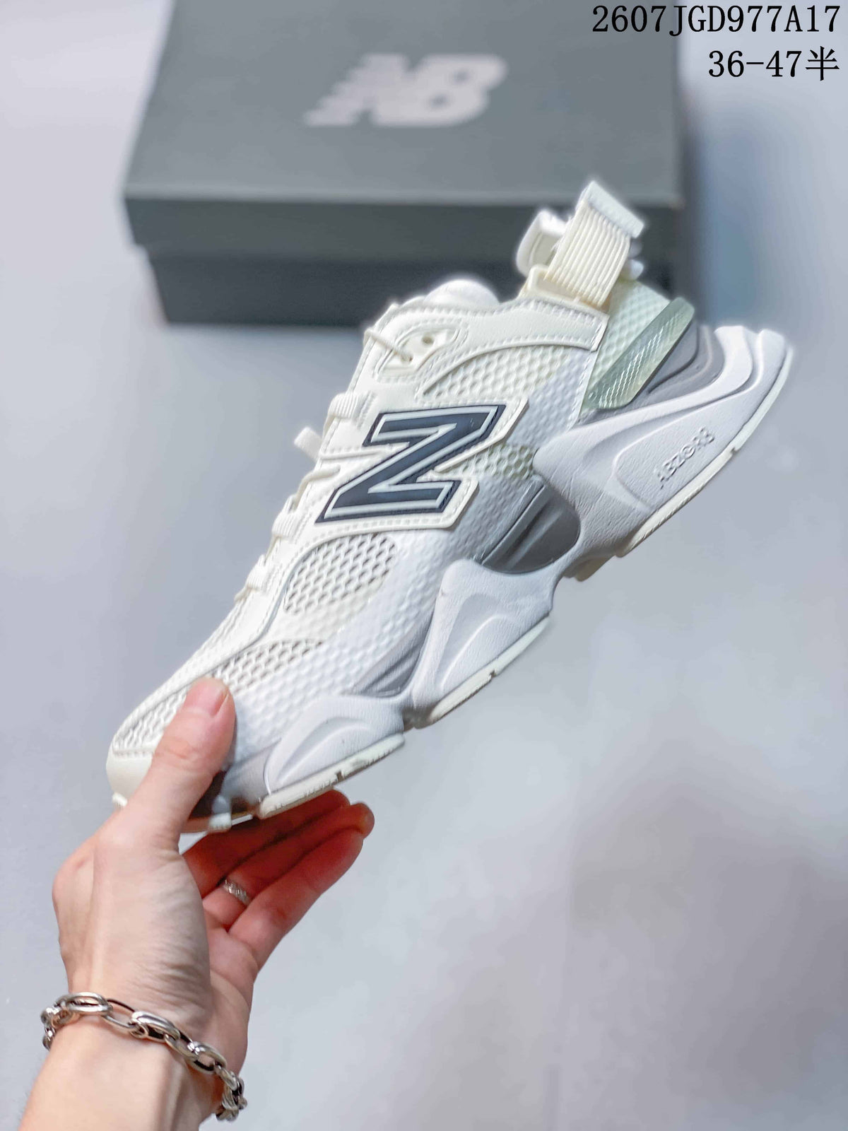 Side profile showing the mesh upper, large navy New Balance branding, heel strap, and sculpted sole.