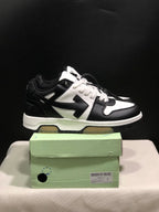 Side view of black and white low-top sneakers with contrasting panels and chunky layered soles.