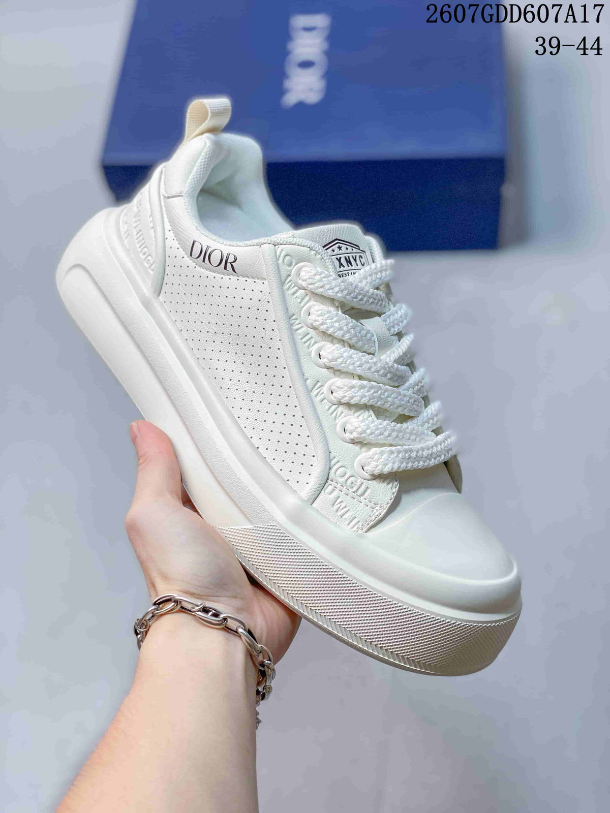 Angled side view of the white sneaker showing Dior branding, perforated side panels, lace-up closure and textured outsole.