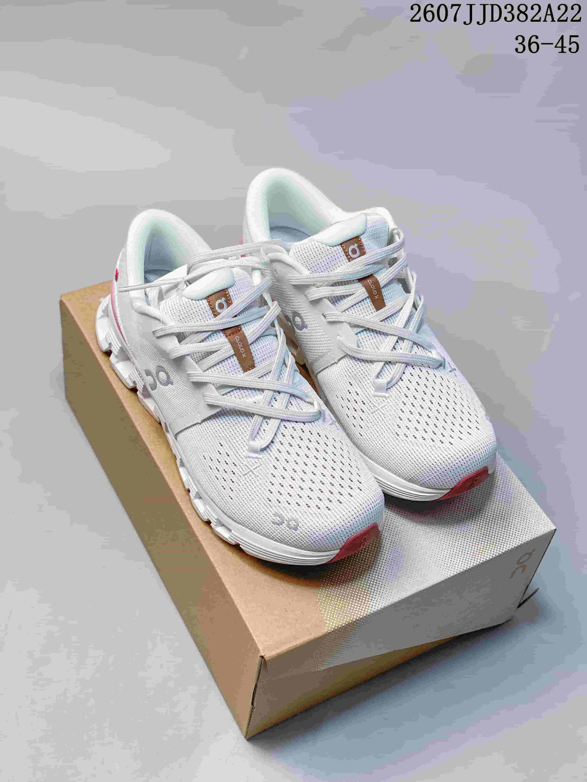 Pair of white and pink On Cloud X 4 low-top sneakers displayed on a shoebox; style code 2607JJD382A22 and size range 36–45 are visible.