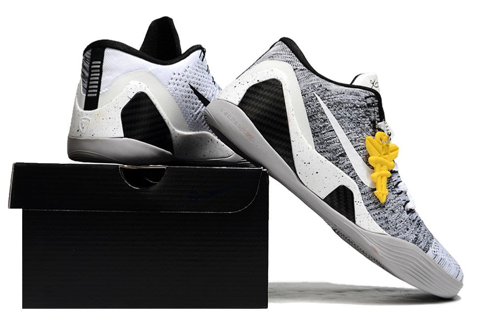 White and black shoes displayed on a black shoebox.
