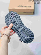 Close-up of the rugged lugged outsole on a silver and black Mizuno sneaker.