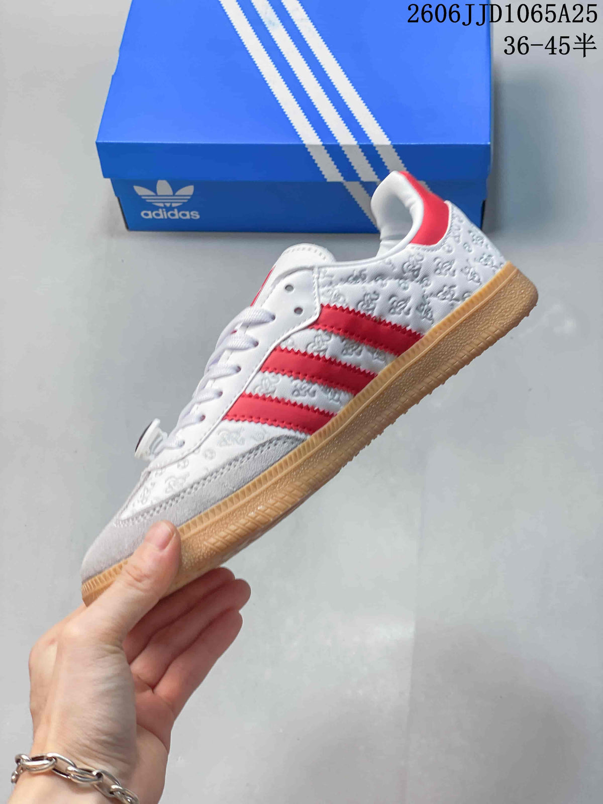 Side profile showing the white low-top sneaker, red three stripes, embossed graphics, and gum-colored outsole.