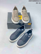 Taupe and charcoal CAT sneakers shown together with branded boxes and low-profile lace-up construction.