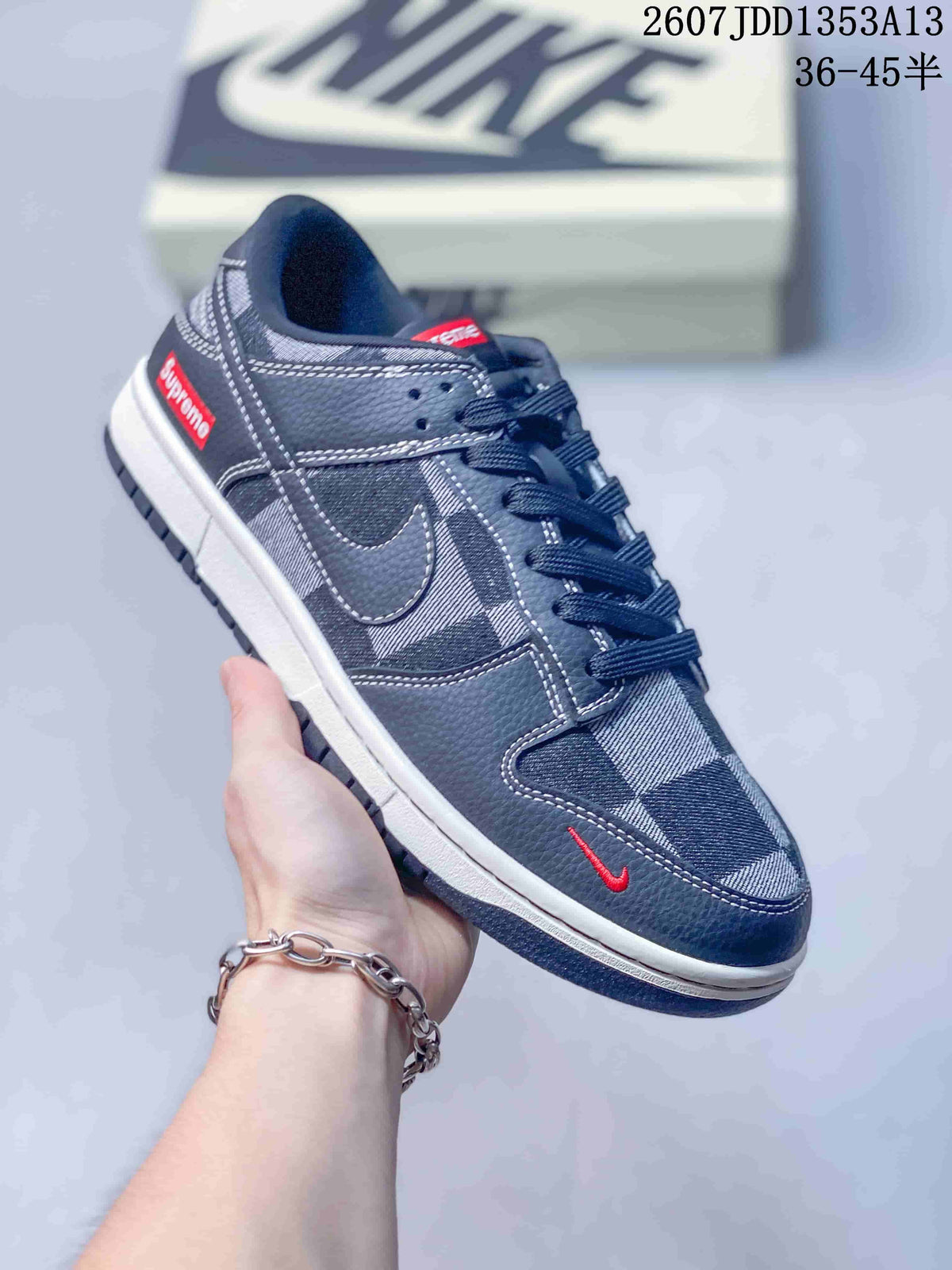 Angled side view showing the navy plaid upper, red heel label, red toe detail, and white midsole.