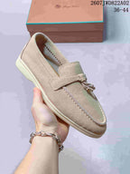 Close side view of a beige loafer showing its flat sole and upper stitching