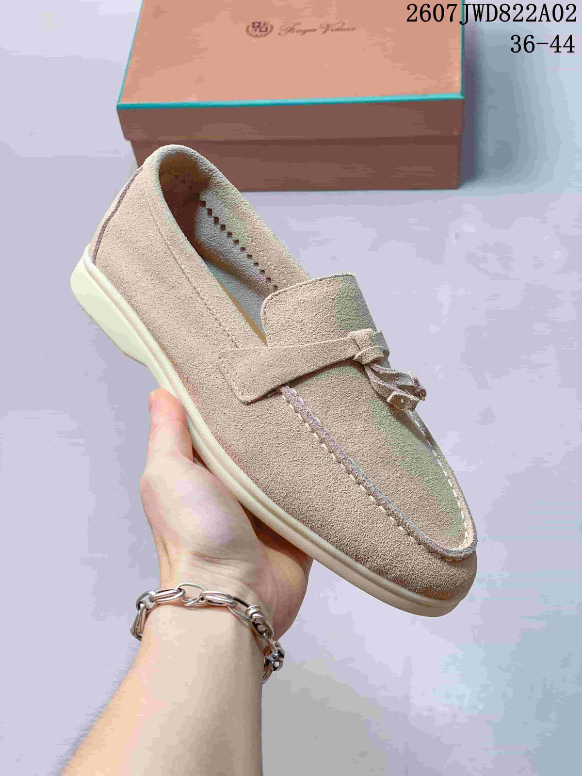 Close side view of a beige loafer showing its flat sole and upper stitching